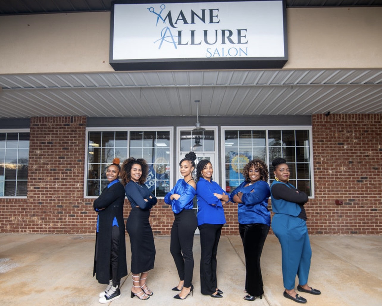 The stylists of Mane Allure standing in front of the salon